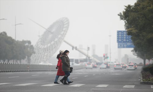 Residents cross the street Thursday in Pudong New Area with masks to filter out the pollution. Photo: Yang Hui/GT