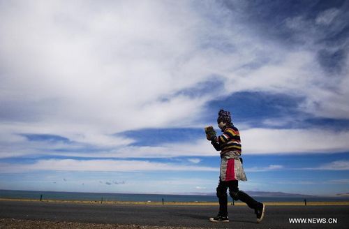 A woman goes on a pilgrimage by the Qinghai Lake in Northwest China's Qinghai Province, October 31, 2012. The Qinghai Lake, China's largest inland saltwater lake, measured 4,402.5 square km, according to the latest remote sensing survey. The figure was the largest in recent 12 years. Photo: Xinhua