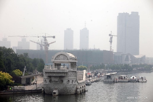 Fog-shrouded buildings are pictured in Tianjin, north China, June 18, 2013. Local meteorological authorities issued a yellow fog alert on Tuesday morning. (Xinhua/Liu Dongyue)