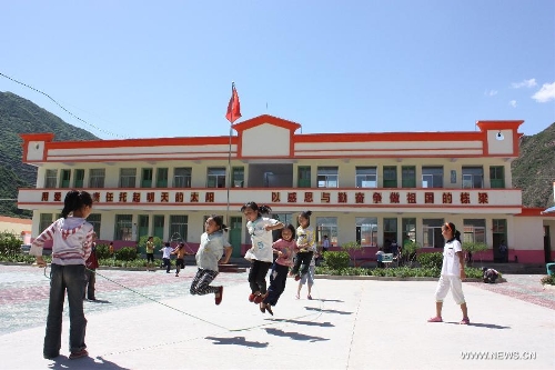 Photo taken on July 19, 2010 shows pupils playing on the playground in a newly-built school in Xinchengzi Township of Longnan City, northwest China's Gansu Province. In the year of 2008, a massive earthquake occurred in Gansu's neighbouring province Sichuan, and Longnan was also battered by the disaster. During the past five years, a total of 3,905 reconstruction projects have been carried out in the city, where over 240,000 households have their houses rebuilt, and hundreds of schools and hospitals have been set up as well. (Xinhua/Wang Yaodong) 