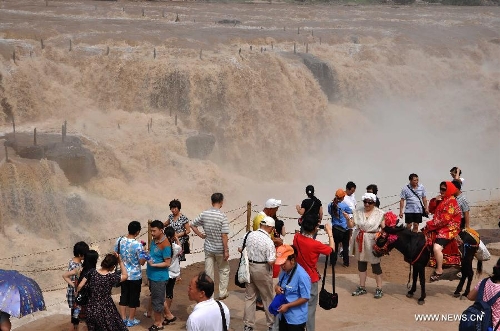 People gather to watch the Hukou Waterfall of the Yellow River in Jixian County, north China's Shanxi Province, June 30, 2013. (Xinhua/Lv Guiming) 