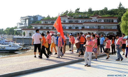 Tourists arrive at the Jingpo Lake scenic area in Mudanjiang, northeast China's Heilongjiang Province, July 7, 2012. About 30 percent more tourists have visited the Jingpo Lake scenic area this year than the same period last year, following a series of promotions. Photo: Xinhua