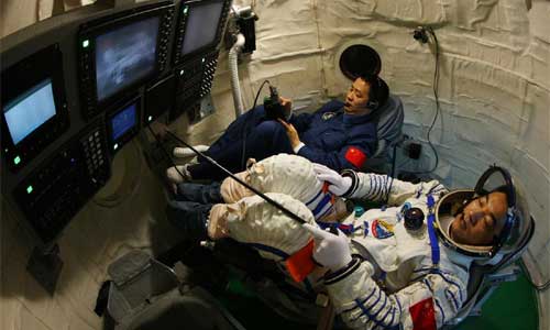 Nie Haisheng (Back) and Zhang Xiaoguang, astronauts of China's Shenzhou-10 manned spacecraft, attend a training of manual docking between Shenzhou-10 spacecraft and orbiting space lab module Tiangong-1, in a simulated reentry capsule April 14, 2013. Photo: Xinhua