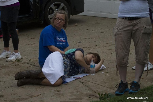 A woman tends to another woman in shock after a tornado in Moore, Oklahoma, the United States, on May 20, 2013. Twenty-four people were killed and 237 others injured when a massive tornado blasted the southern suburbs of Oklahoma City, the capital of the U.S. state of Oklahoma, on Monday, state officials said Tuesday. (Xinhua/Marcus DiPaola)
