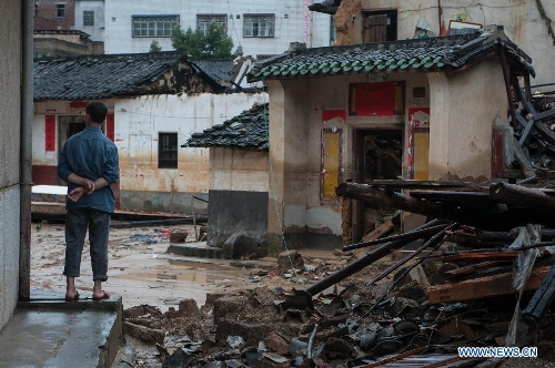&nbsp;A villager stands in front of houses destroyed by the rainstorm in Guangfu Town of Jiaoling County, Meizhou City, south China's Guangdong Province, May 22, 2013. Meizhou City was hit by a rainstorm on May 19, which killed one people and destroyed 951 houses, leaving 180, 000 people affected in Jiaoling County. (Xinhua/Mao Siqian) 