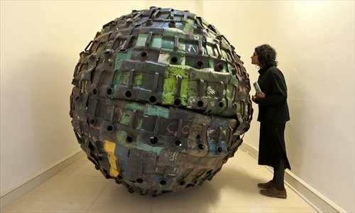 A visitor looks at an artwork by Beninese artist Romuald Hazoum titled <em>Giant Ball</em> displayed at the Contemporary African Arts Fair at Somerset House in Central London on Tuesday. Photo: AFP 