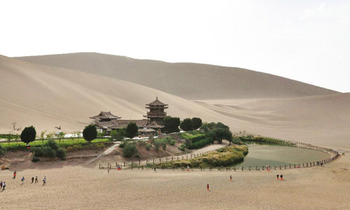 People visit the scenic spot of Crescent Lake in Dunhuang city, Northwest China's Gansu Province, August 30, 2012. Dunhuang, a major stop on the ancient Silk road well known for its Mogao Caves (Caves of 1,000 Buddhas), Crescent Lake and Mingsha Mountain, has witnessed a 40 percent increase in both tourists number and tourism industry's revenue in the first eight months in 2012 compared with the same period of last year. Photo: Xinhua