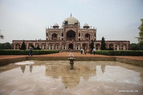 Tourists visit Humayun's Tomb in New Delhi, capital of India, May 12, 2013. Humayun's Tomb, located in east New Delhi, was built in 1569 to 1570 by Humayun's widow. As a precursor to the Taj Mahal, it stands on a platform of 12,000 square meters and reaches a height of 47 meters. The earliest example of the Persian influence in Indian architecture, the tomb itself is in the center of a large garden, surrounded by 12 hectares of gardens with pools joined by channels. The tomb brought Persian style to Delhi, but the two-tone combination of red sandstone and white marble is local, which shows the merging of different cultures. Humayun's Tomb was inscribed on the World Heritage List by the United Nations Educational, Scientific and Cultural Organization in 1993. (Xinhua/Zheng Huansong) 