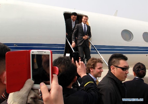 British soccer player David Beckham (rear R) arrives at the Qingdao Liuting Airport in Qingdao, east China's Shandong Province, March 22, 2013. Beckham visited Qingdao Jonoon Soccer Club as the ambassador for the youth football program in China and the Chinese Super League Friday. (Xinhua/Li Ziheng) 