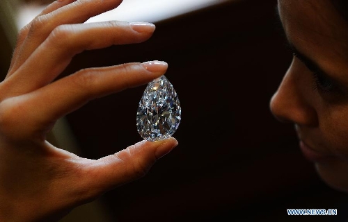 A worker shows the 101.73-carat diamond to the media at the Christie in Geneva, Switzerland, April 30, 2013. Christie will hold spring sale of Jewels auction in Geneva on May 15, 2013. Led by a truly sensational pear-shaped, D colour, flawless diamond of 101.73 carats, the sale will reach to an estimated combined total of 65 million dollars. This Type IIA Flawless gem was found at the Jwaneng mine in Botswana and took 21 months to polish. This gemstone is estimated to be sold at a price between 20 to 30 million dollars and the successful buyer will have the privilege of endowing the diamond a name. (Xinhua/Wang Siwei) 