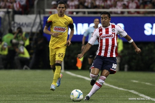 Chivas' Marco Fabian de la Mora (R) vies for the ball with Paul Aguilar of America during a Liga MX soccer match at the Omnilife Stadium in Zapopan, Mexico, on March 31, 2013. (Xinhua/StraffonImages) 