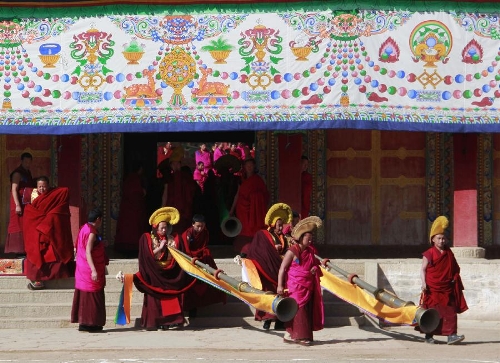  Buddhist monks carry long horns as they head for a ritual dance which prays for good fortune and harvest at the Labrang Monastery in Xiahe County, Gannan Tibetan Autonomous Prefecture, northwest China's Gansu Province, Feb. 23, 2013. The Labrang Monastery is among the six great monasteries of the Geluk school of Tibetan Buddhism. (Xinhua/Shi Youdong) 