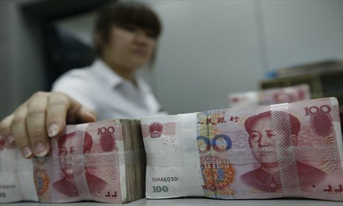A cashier at a State-owned bank counts money Wednesday in Huaibei, East China's Anhui Province. Photo: IC