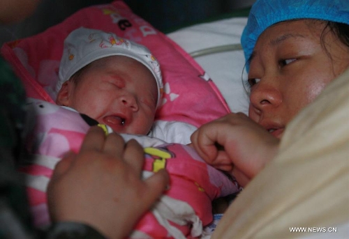 Liu Li, a villager of Luyang Township of Lushan County, is seen with her newborn baby girl Zhang An in the quake-hit Lushan County, southwest China's Sichuan Province, April 22, 2013. Liu Li gave birth to the baby girl Zhang An on Monday night. A 7.0-magnitude earthquake jolted Lushan County on April 20, leaving at least 192 people dead and 23 missing. More than 11,000 people were injured. (Xinhua/Jin Liwang) 