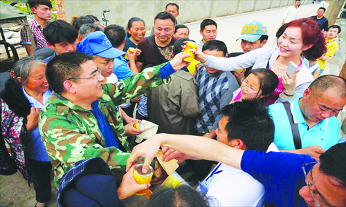 Chen Guangbiao (first from left) gives drinks to people in earthquake-stricken Ya'an. Photo: CFP