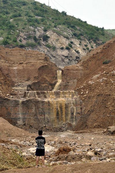 A man stands in front of the collapsed rainwater pooling dam of the Shenjiakeng Reservoir in Daishan County, east China's Zhejiang Province, Aug. 10, 2012. The death toll from a flood that occurred Friday morning following the breach of the Shenjiakeng Reservoir has risen to ten, local rescuers said. The flood also injured 27 people.  Photo: Xinhua