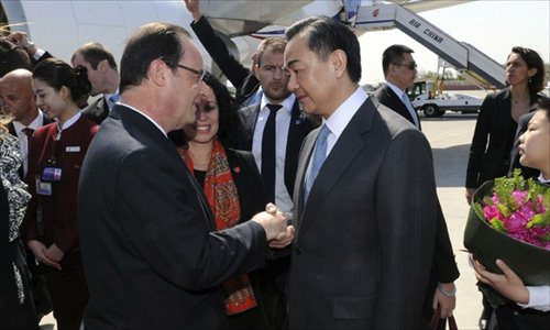 French President Francois Hollande (L) is greeted by Chinese Foreign Minister Wang Yi upon his arrival in Beijing, capital of China, April 25, 2013, for a state visit to China. Photo: Xinhua