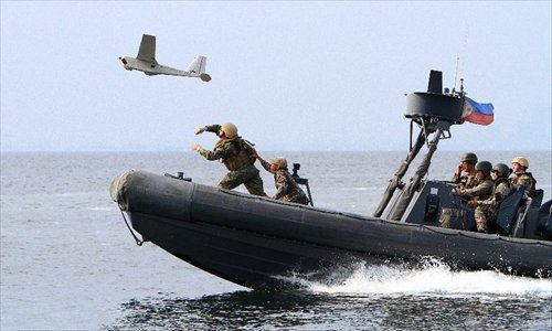 US navy soldiers and their Philippine counterparts launch an unmanned aerial vehicle (UAV) during a joint military exercises between the Philippines and the United States at the South China Sea, June 28, 2013. The Philippines and U.S. Naval forces began joint military exercises codenamed Cooperation Afloat Readiness and Training (CARAT) at the South China Sea on June 27 to enhance the capability of both sides through practical exercises and lectures. Photo: Xinhua