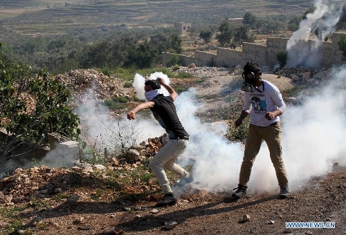 Palestinian protesters hurl stones at Israeli soldiers during a protest against the expanding of Jewish settlements in Kufr Qadoom village near the West Bank city of Nablus on April 26, 2013. (Xinhua/Ayman Nobani) 