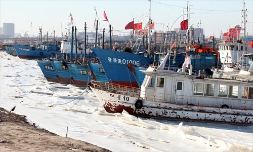 Fishing boats rest at a frozen port in Tianjin municipality on Wednesday. The water temperature along the coastline of North China will keep dropping due to a new cold front, according to meteorologists. Photo: CFP