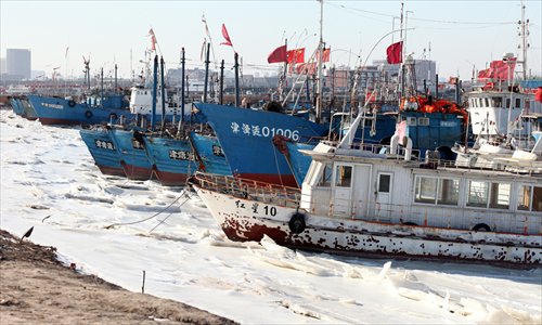 Fishing boats rest at a frozen port in Tianjin municipality on Wednesday. The water temperature along the coastline of North China will keep dropping due to a new cold front, according to meteorologists. Photo: CFP