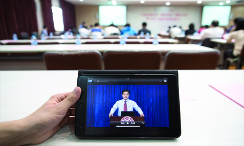 A university student watches an open course on a computer tablet in Shanghai on April 16, 2013. Photo: CFP