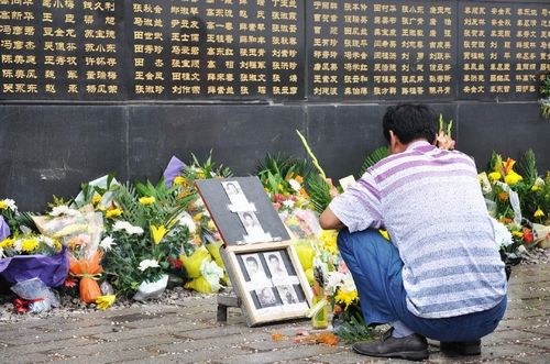 A man places a photo of his loved ones who were killed in the 1976 earthquake in front of the memorial wall bearing the names of the earthquake victims in Tangshan, North China's Hebei Province, July 28, 2012. Saturday marked the 36th anniversary of the Tangshan earthquake. Tangshan lost 240,000 lives to a devastating 7.8-magnitude earthquake on July 28, 1976, which was believed to be one of the deadliest natural disasters of the 20th century. Photo: Xinhua