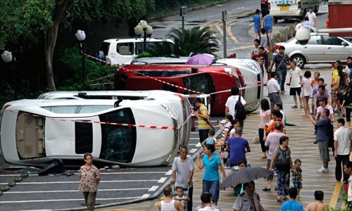 People pass by overturned Japanese cars in Shenzhen on August 17 following a mass protest against Japan over the Diaoyu Islands dispute. Photo: northnews.cn