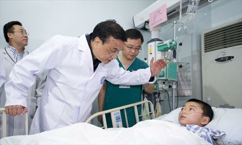 Chinese Premier Li Keqiang (2nd R) visits a patient seriously injured in an earthquake, at Huaxi Hospital in Chengdu, capital of Southwest China's Sichuan Province, April 21, 2013. A 7.0-magnitude earthquake jolted Lushan county of Sichuan Province on April 20 morning. Photo: Xinhua 