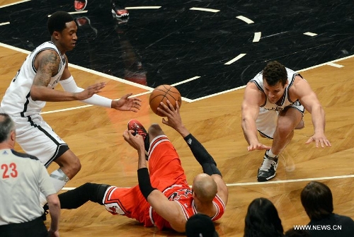 Chicago Bulls' Taj Gibson (C) vies with Brooklyn Nets' Kris Humphries (R) during Game 7 of their NBA Eastern Conference Quarterfinals basketball playoff series in New York, the United States, May 4, 2013. Bulls won 99-93 Saturday to reach the second round with 4-3 in the first-round series. (Xinhua/Wang Lei) 