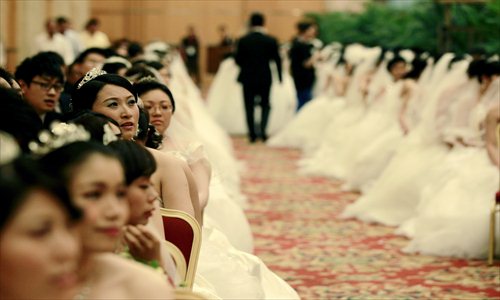 One hundred couples get married at the Shanghai International Convention Center on Monday, May 20, known as Love Confession Day. The pronunciation of May 20 in Chinese sounds similar to the words 