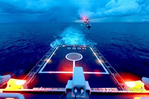 The photo shows that a helicopter is about to land on the deck at night. Photo: Chinamil.com.cn