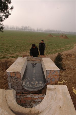 People inspect a broken tombstone in Zhoukou on February 18. The tomb was destroyed as part of a government campaign to reclaim farmland. Photo: CFP