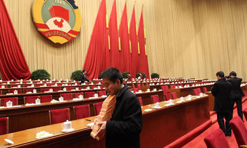 Staff members clean up the conference hall after the closing meeting of the Fifth Session of the 11th National Committee of the Chinese People's Political Consultative Conference (CPPCC) at the Great Hall of the People in Beijing, capital of China, March 13, 2012. Photo: Xinhua