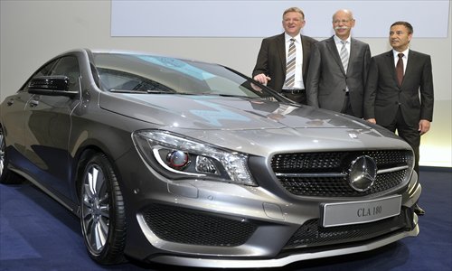 Daimler AG board members Andreas Renschler (L) and Bodo Uebber (R), and CEO Dieter Zetsche (C), pose Thursday for photographers next to a Mercedes-Benz at the German auto giant's annual conference in Stuttgart, Germany. Daimler said that its net profit rose by 8 percent to 6.495 billion euros ($8.8 billion) in 2012 on the back of record unit sales and revenues. Photo: AFP