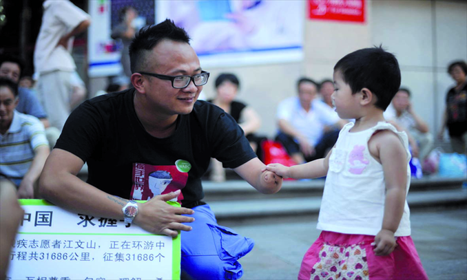 Jiang Wenshan shakes the hand of a passerby in Wanfujing with his disabled arm.