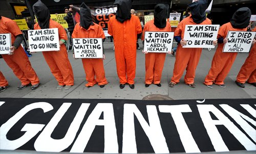 People parade in orange jumpsuits and black hoods as activists demand the closing of the US military's detention facility in Guantanamo during a protest, as part of the Nationwide for Guantanamo Day of Action, on Thursday in New York's Times Square. The Guantanamo jail, in a US Navy base in Cuba, was opened in 2002 to hold prisoners taken in the 