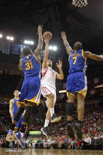 Carlos Delfino (C) of Houston Rockets goes to the basket during the NBA game against Golden State Warriors in Houston, the United States, on March 17, 2013. (Xinhua/Song Qiong) 