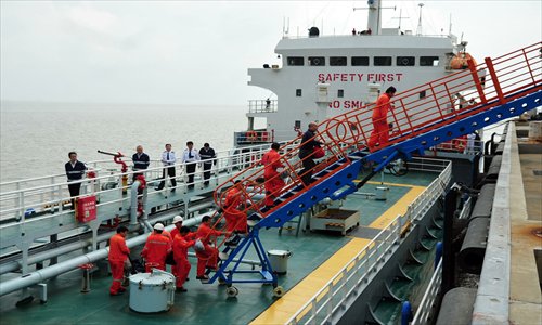 Sailors disembark Wednesday from the cargo ship that rescued them on the East China Sea Tuesday. The 10 sailors had to abandon their freighter during Typhoon Fitow. Photo: Cai Xianmin/GT