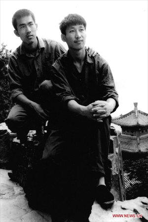 File photo taken in 1977 shows Xi Jinping (R) poses for photo as a college student. (Xinhua)