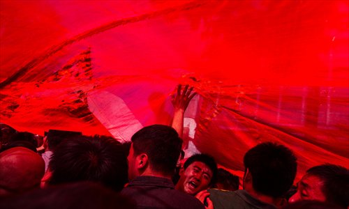 People protest under a large Chinese national flag against Japan's 