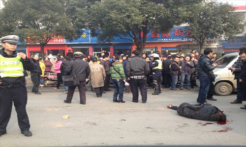 A man suffering head wounds is left unattended as a crowd looks on in Changsha, Hunan Province, Thursday. The man was reportedly involved in a brawl in which another man was shot in the face. Police say the men sustained only minor injuries. Photo: CFP