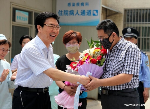 The H7N9 bird flu patient surnamed Zhang (R) receives flowers from a medical staff member at Zaozhuang Municipal Hospital in Zaozhuang City, east China's Shandong Province, March 16, 2013. Zhang has recovered from the disease as the first H7N9 bird flu infection in Shandong Province. (Xinhua/Sun Zhongzhe)&nbsp; 