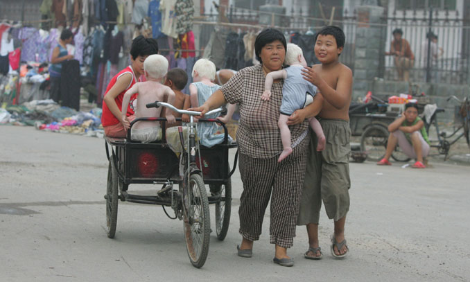 Yuan Lihai, who had been running a foster home since 1987, walks with her adopted children in this file picture taken on July 21, 2006, in Lankao, Central China’s Henan Province. Photo: CFP