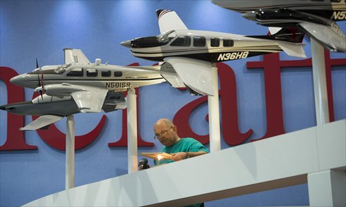 A worker applies the finishing touches to displays for the 13th Annual European Business Aviation Convention and Exhibition (EBACE) press day, at the Geneva Palexpo Conference Center, adjacent to Geneva Airport, in Geneva, Switzerland, on Monday. The exhibition takes place from Tuesday to Thursday. Photo: CFP