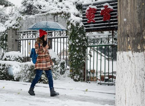 A woman walks on a snow-covered street in Changchun, capital of Northeast China's Jilin Province, October 22, 2012. Most parts of Jilin witnessed snowfall on Monday. Photo: Xinhua