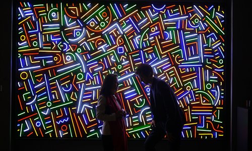 Two visitors talk to each other in front of artist Lu Xinjian's <em>Shanghai City Light</em>. Photos: Courtesy of Art Labor Gallery