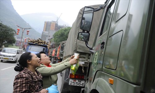 Locals from Baoxing county in Sichuan Province, one of the hardest-hit areas of the 7.0-magnitude earthquake that occurred Saturday morning, send water to military rescuers on Monday. The death toll of the quake had risen to more than 190 as of Monday night. Photo: Li Hao/GT
