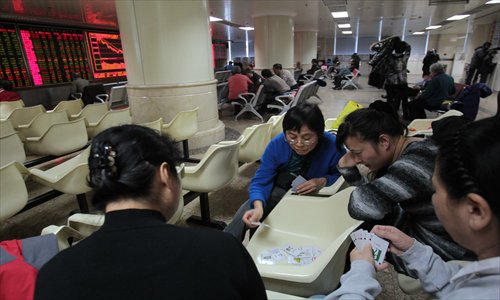 Individual investors play cards at a securities company in Beijing Monday. Photo: CFP