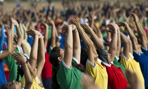 Indian schoolchildren perform morning yoga sun salutations (Surya Namaskar) at Ramlila Maidan in New Delhi on Monday. Surya Namaskar programs were organized Monday across the country on the 150th birth anniversary of revered Hindu monk Swami Vivekananda. Photo: AFP